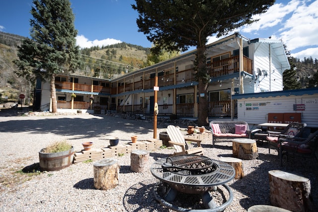 view of patio featuring a balcony, a mountain view, and a fire pit