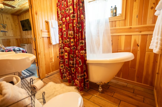 bathroom featuring wood walls, wood ceiling, hardwood / wood-style floors, ceiling fan, and toilet