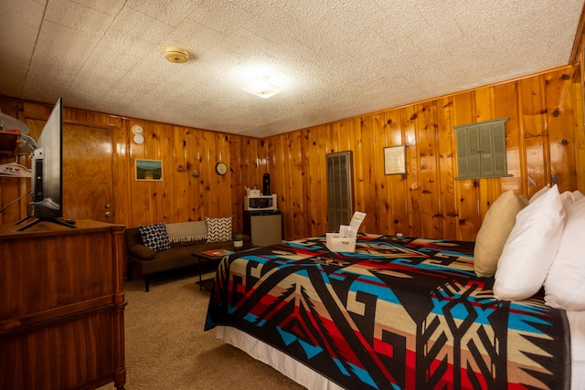 bedroom with wood walls, a textured ceiling, and carpet flooring