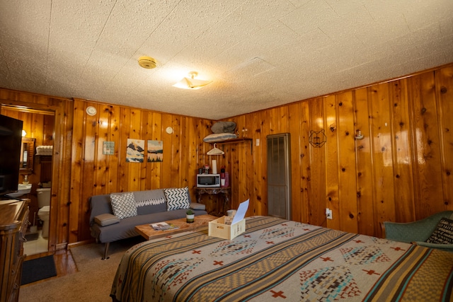 carpeted bedroom featuring a textured ceiling and wood walls