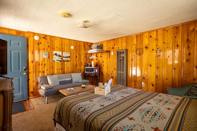 carpeted bedroom with wooden walls and a textured ceiling