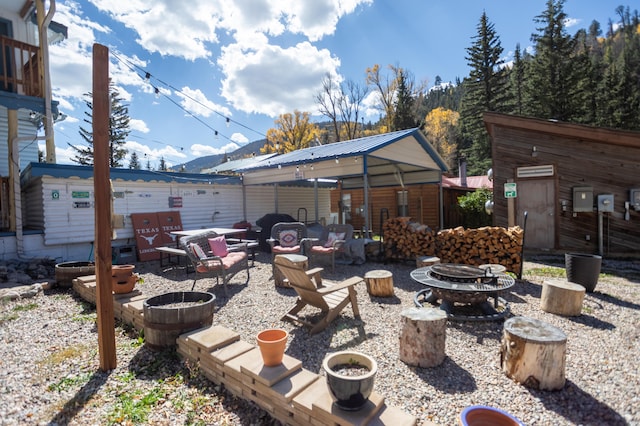 view of patio featuring an outdoor fire pit and an outbuilding