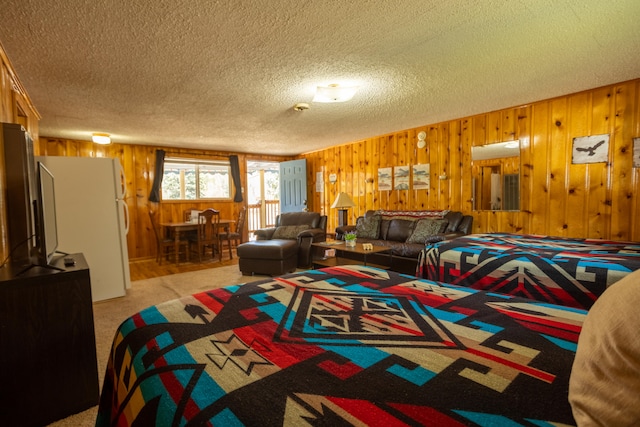 carpeted living room with wood walls and a textured ceiling