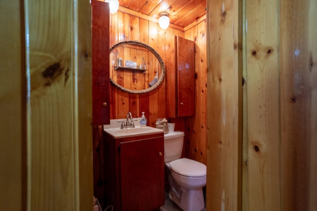 bathroom featuring vanity, wood ceiling, wood walls, and toilet