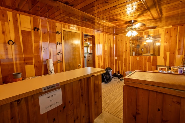 interior space featuring light carpet, wood ceiling, wood walls, and ceiling fan