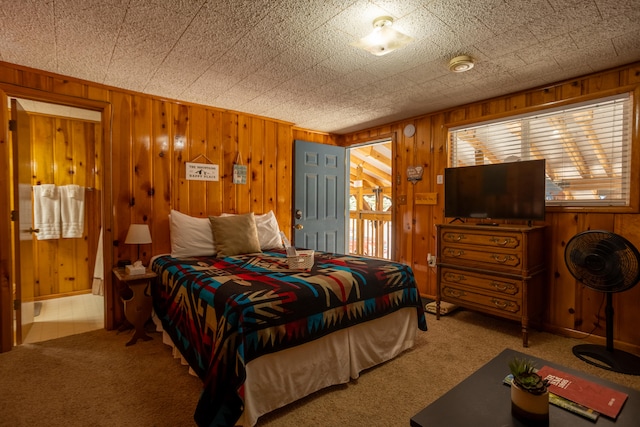 carpeted bedroom featuring wooden walls