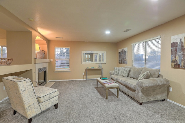 living room with carpet flooring and a tile fireplace