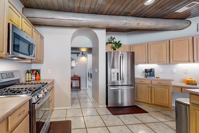 kitchen featuring light brown cabinets, appliances with stainless steel finishes, washing machine and clothes dryer, and light tile patterned flooring