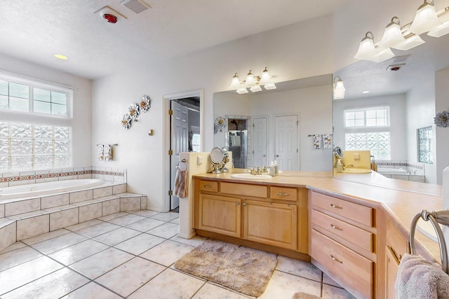 bathroom featuring vanity, tile patterned flooring, and tiled bath