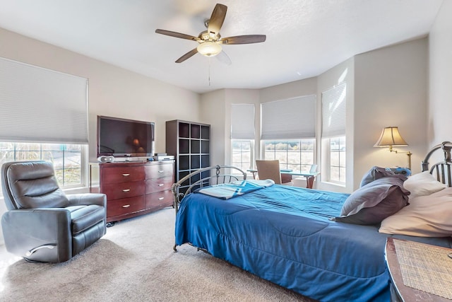 carpeted bedroom featuring ceiling fan and multiple windows