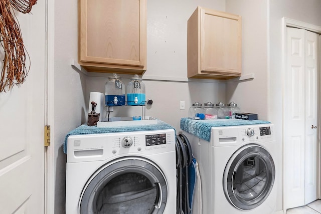 laundry area with washing machine and clothes dryer and cabinets