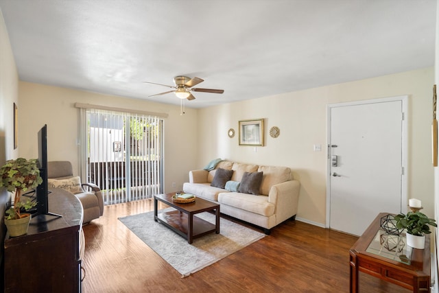 living room with ceiling fan and dark hardwood / wood-style flooring