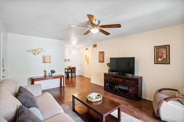 living room featuring ceiling fan and dark hardwood / wood-style flooring