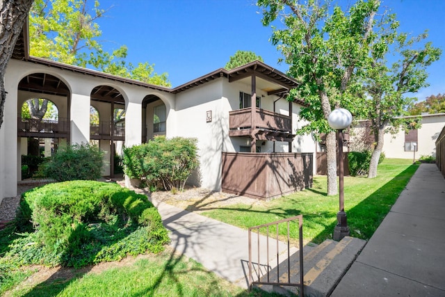 mediterranean / spanish-style house with a balcony and a front yard