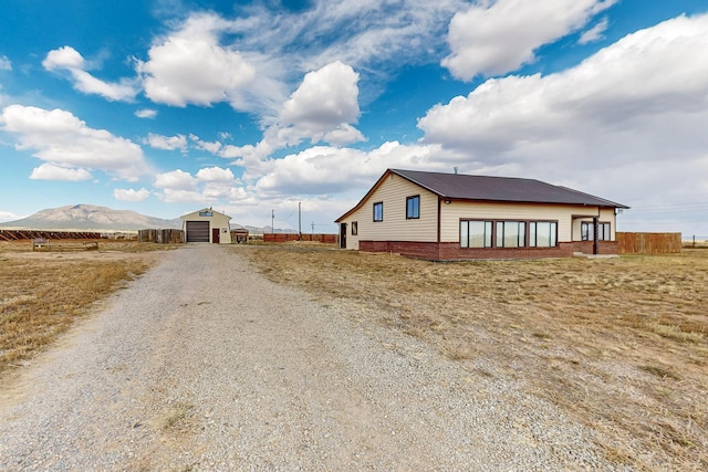 view of home's exterior with a mountain view, a garage, and an outbuilding