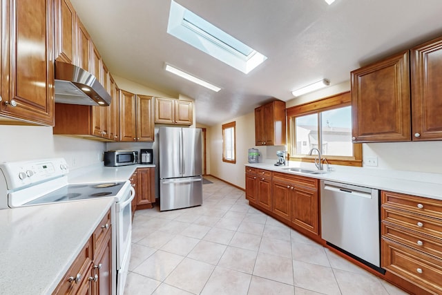 401A Nm-344, Edgewood, NM 87015 - kitchen featuring vaulted ceiling with skylight, a sink, ventilation hood, light countertops, and appliances with stainless steel finishes