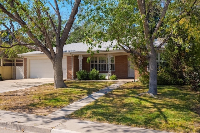 ranch-style house with covered porch, a front yard, and a garage