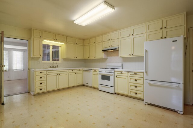 kitchen with white appliances, sink, backsplash, and cream cabinets