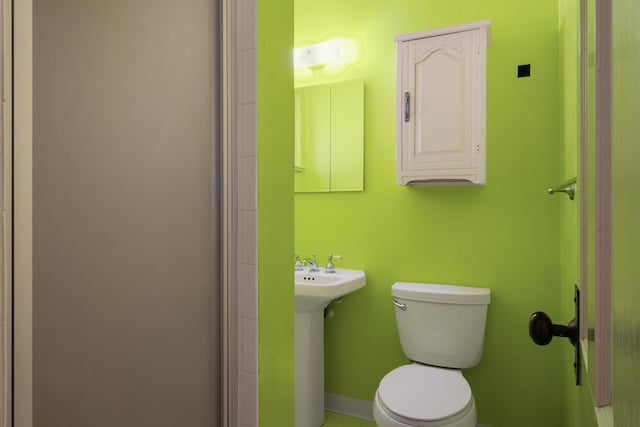 bathroom with sink, toilet, and an enclosed shower