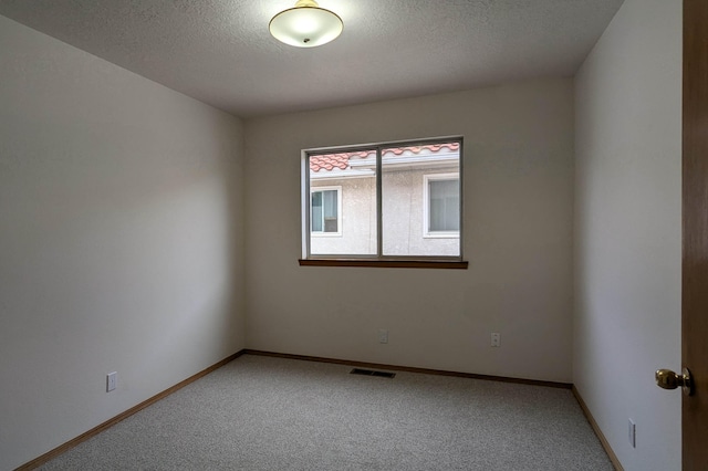 spare room with a textured ceiling and carpet floors