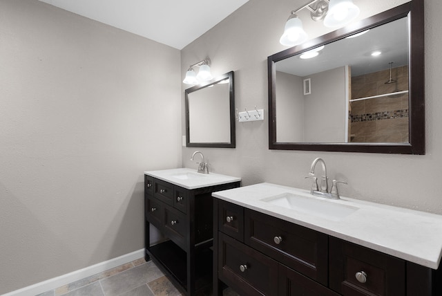 bathroom with a tile shower and vanity