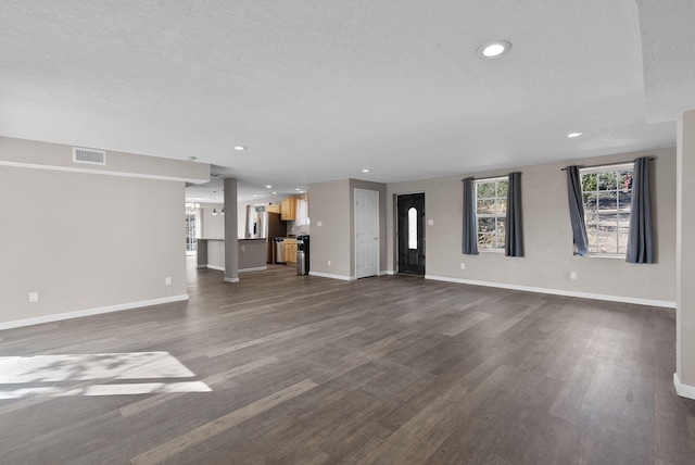 unfurnished living room featuring a textured ceiling and dark hardwood / wood-style flooring