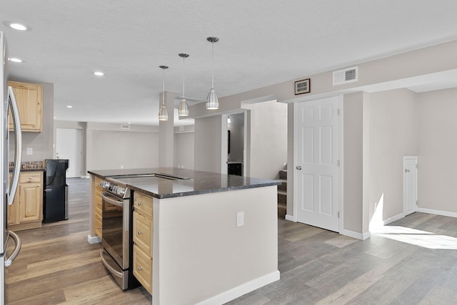 kitchen with electric range, a center island, dark stone countertops, light hardwood / wood-style floors, and decorative light fixtures