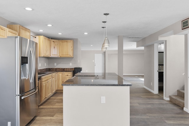 kitchen featuring pendant lighting, light brown cabinets, a kitchen island, and stainless steel fridge with ice dispenser