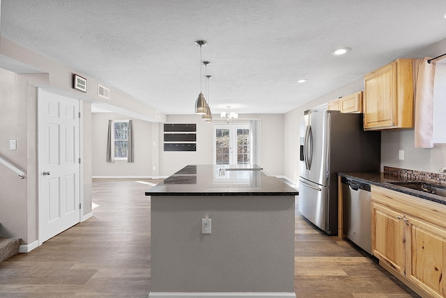 kitchen featuring sink, pendant lighting, light brown cabinets, dishwasher, and a kitchen island