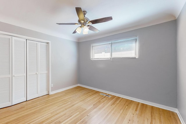 unfurnished bedroom with a closet, hardwood / wood-style floors, and ceiling fan