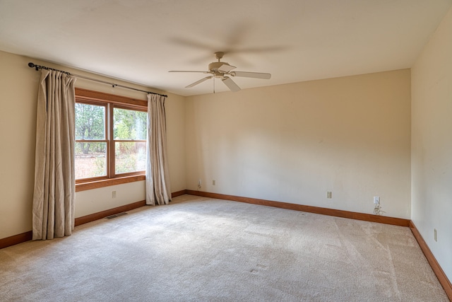 carpeted spare room featuring ceiling fan