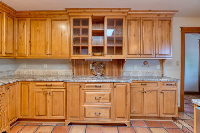 kitchen with light tile patterned flooring and light stone counters