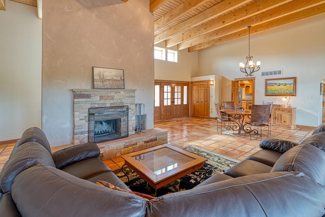 living room featuring beamed ceiling, light tile patterned flooring, an inviting chandelier, a fireplace, and a towering ceiling