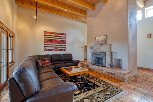 living room featuring a towering ceiling, wood ceiling, beamed ceiling, and a fireplace