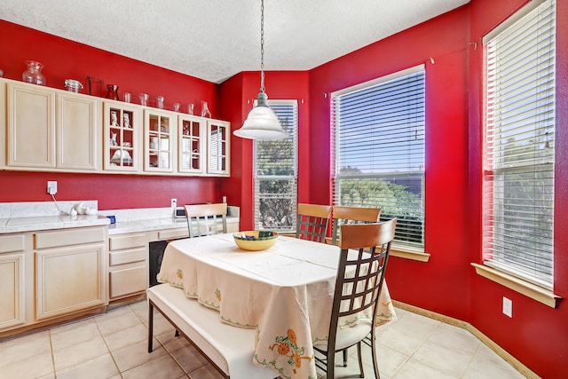 dining room featuring a textured ceiling, light tile patterned flooring, and plenty of natural light