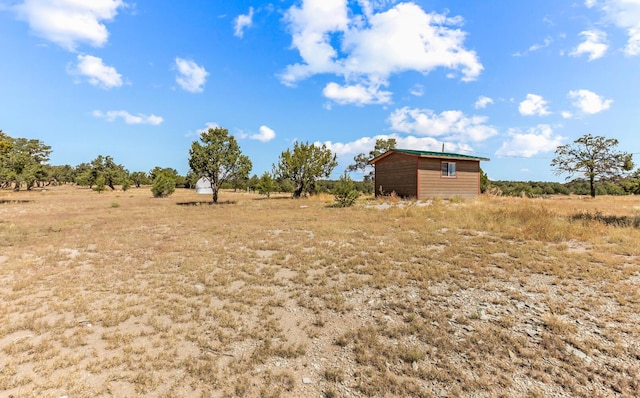 view of yard featuring a rural view and an outdoor structure