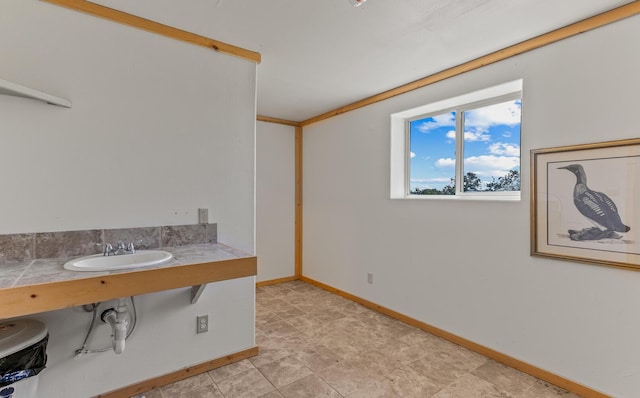 bathroom with baseboards and a sink