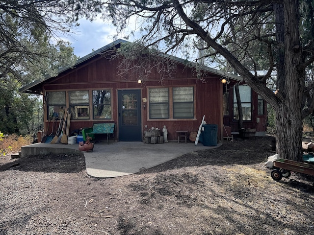 rear view of property with a storage unit