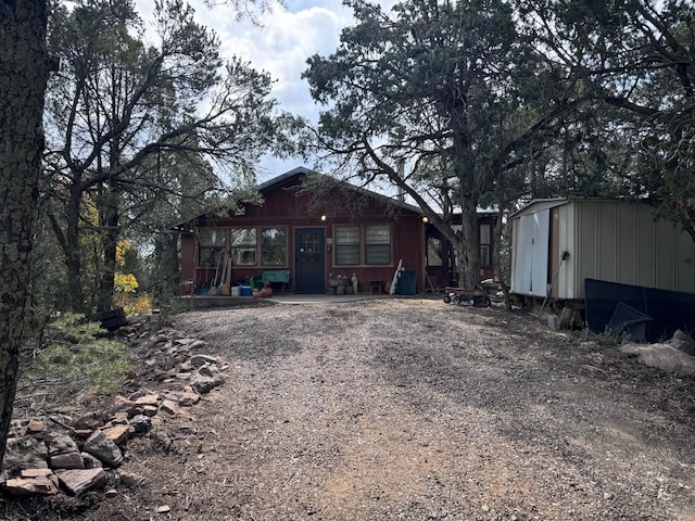 rear view of property with a storage unit