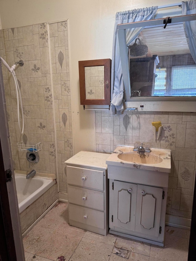 bathroom featuring tiled shower / bath and vanity