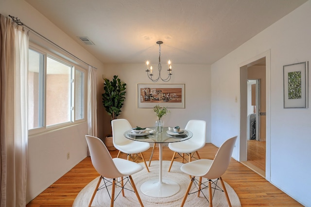 dining area featuring a notable chandelier and light wood-type flooring