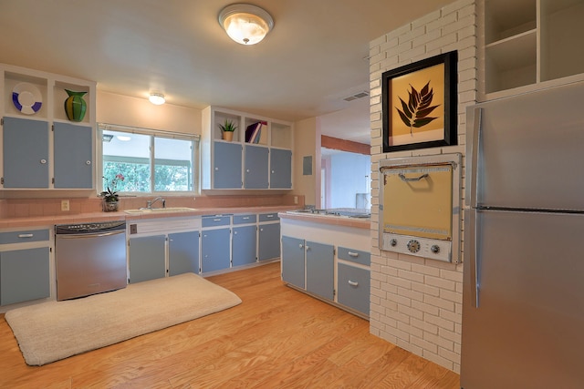 kitchen with tile countertops, brick wall, sink, and white electric stovetop