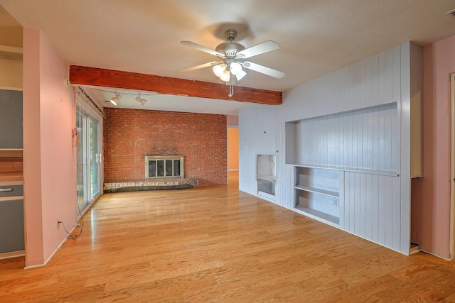 spare room with beam ceiling, light wood-type flooring, and ceiling fan