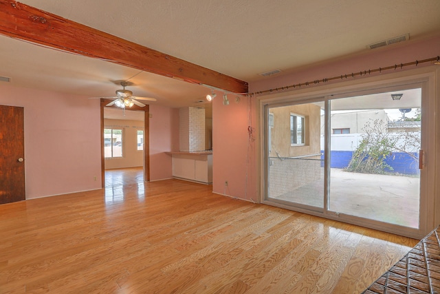 empty room with a textured ceiling and light hardwood / wood-style floors