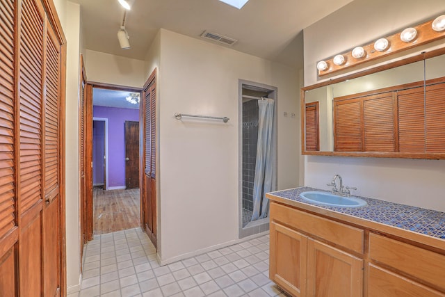 bathroom with vanity, tile patterned floors, and walk in shower