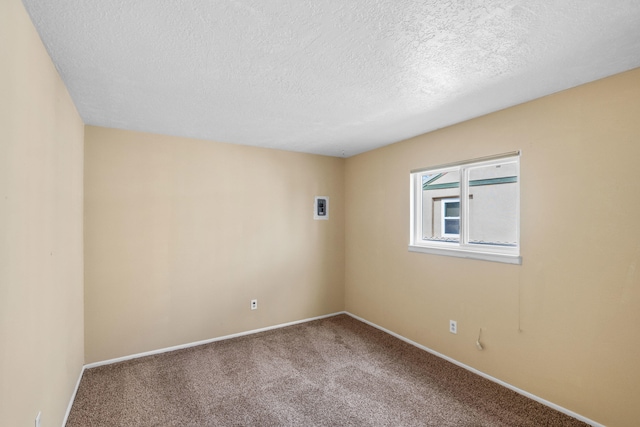 carpeted spare room with a textured ceiling