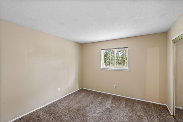 empty room featuring a textured ceiling and carpet flooring