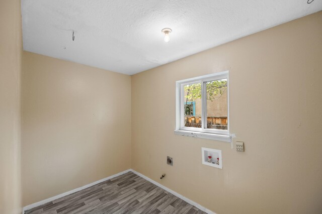 clothes washing area with a textured ceiling, electric dryer hookup, washer hookup, and hardwood / wood-style flooring