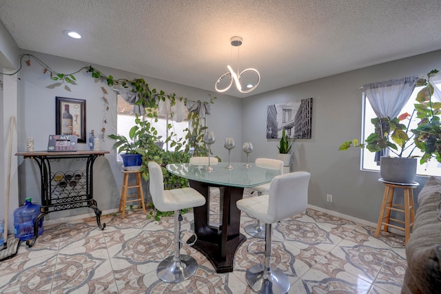 tiled dining space with a chandelier and a textured ceiling