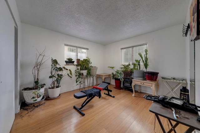 exercise area with a textured ceiling, plenty of natural light, and hardwood / wood-style floors